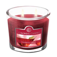 a red candle that is sitting in front of a white background with the words colonial candle cranberry creamo on it