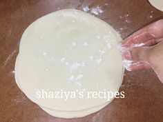 a person is kneading dough on a wooden table