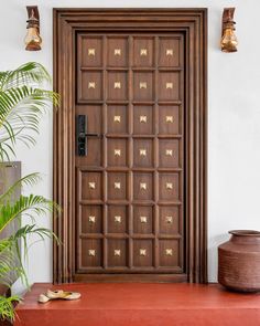 a wooden door sitting next to a potted plant