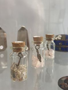 three glass bottles filled with different types of rocks