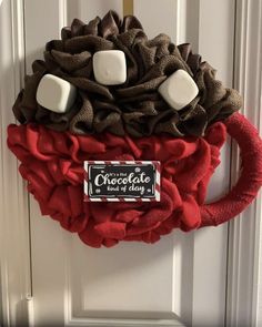 a door hanger with marshmallows and chocolate on it's side