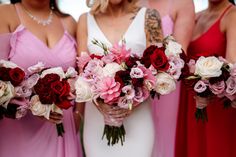 bridesmaids in pink dresses holding bouquets of red, white and pink flowers