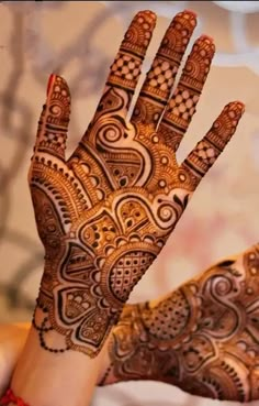 a woman's hand with henna tattoos on it