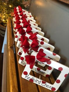 a row of red and white valentine's day signs on a wooden table next to a christmas tree