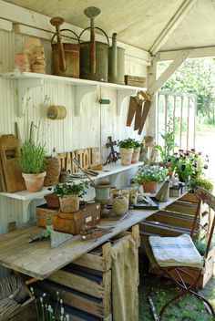 an outdoor room with lots of potted plants on the table and shelves above it