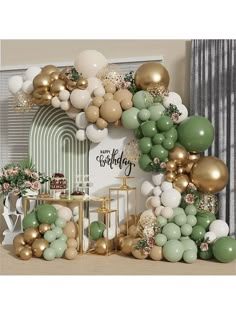 a birthday party with balloons and gold, white and green decorations on the wall in front of a cake table