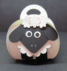 a black and white sheep with flowers on it's head sitting in a box