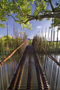 a bridge that is suspended over water with lots of metal bars on the bottom and sides