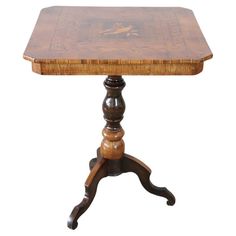 an antique wooden table with turned legs and a carved wood top, on a white background