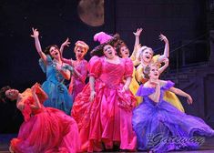 a group of women in colorful dresses on stage