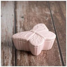 a white ceramic container sitting on top of a wooden table