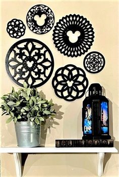 a white shelf topped with a potted plant next to metal circles