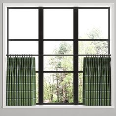 an open window with green curtains and trees outside