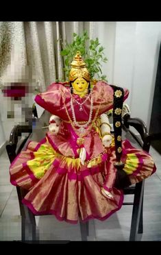 an idol sitting on top of a chair next to a potted plant