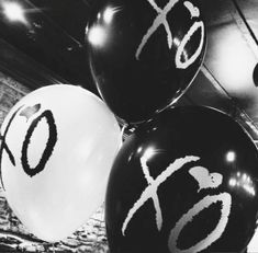 black and white balloons with chinese writing on them in an indoor setting, one balloon has the number six printed on it