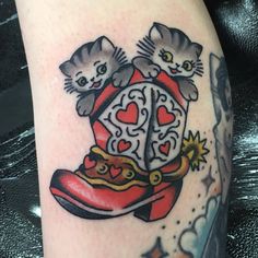 a tattoo with two cats sitting on top of a shoe