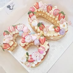 there is a cake shaped to look like the number 50 with strawberries and flowers on it