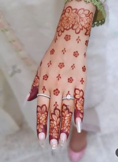 a woman's hand with henna tattoos on it