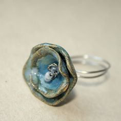 a close up of a ring with a small animal in it's center on a table