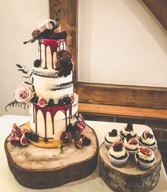 a wedding cake and cupcakes on a table