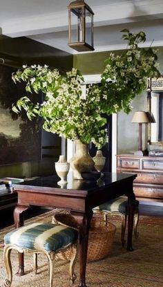 a living room filled with lots of furniture and flowers on top of a wooden table