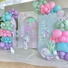 there are balloons and other items on the table in this room that is decorated with pastel colors