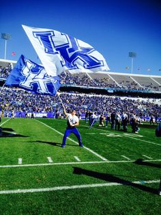 a man holding a flag on top of a football field