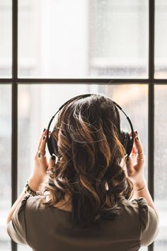 a woman listening to headphones in front of a window with the words cloud armor on it