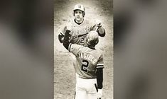 two baseball players standing next to each other on top of a field in black and white