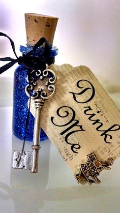 a bottle with a key attached to it sitting on a table next to a cork