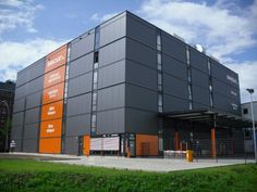 an orange and gray building sitting on top of a lush green field