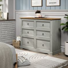 a bedroom scene with focus on the chest of drawers and wall art hanging above it