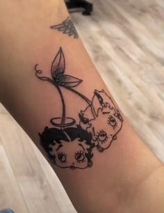 a person with a tattoo on their arm that has an image of two cats and a flower