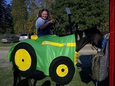 a woman riding on the back of a horse covered in a green and yellow blanket