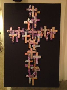 a cross made out of colored paper on a black background