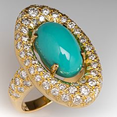 This captivating turquoise ring is centered with an oval turquoise cabochon, weighing an estimated 4.62 carats, in a four-prong setting. The center is surrounded by a halo, bead set with fifty-four (54) round brilliant cut diamonds. The shoulders are each bead set with ten (10) round brilliant cut diamonds. The ring measures 26.4mm at the top, rises 8.5mm above the finger, tapering to 2.4mm wide and 1.0mm thick at the base of the shank. The ring is currently a size 6. Luxury Oval Turquoise Ring, Luxury Turquoise Oval Cabochon Ring, Luxury Oval Turquoise Gemstone Ring, Elegant Turquoise Ring With Polished Finish, Formal Fine Jewelry Turquoise Cabochon Ring, Formal Oval Cabochon Turquoise Ring, Formal Turquoise Cabochon Ring Fine Jewelry, Luxury Turquoise Cabochon Ring, Formal Turquoise Cabochon Ring