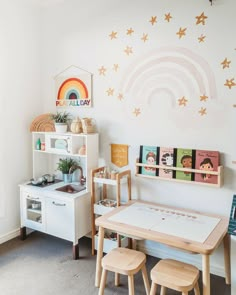 a child's playroom with wooden furniture and wall decor, including a rainbow mural