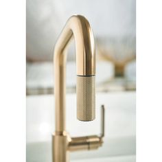 a kitchen faucet with a brass finish and an air freshener on the side