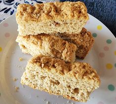 three pieces of biscuit sitting on top of a white plate with multicolored dots