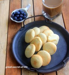 some blueberries are on a plate next to a cup of coffee