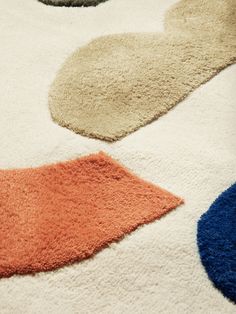 an area rug with different colors and shapes on the floor, including orange, blue, beige, and white