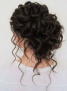 the back of a woman's head, with curly hair and white shirt on