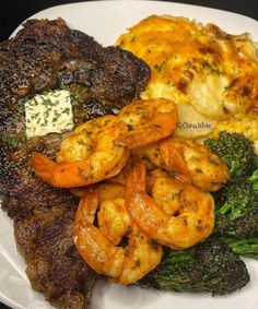 a white plate topped with steak, shrimp and broccoli