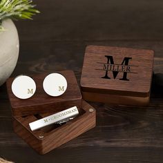 two personalized wooden cufflinks and a pen in a box on a table