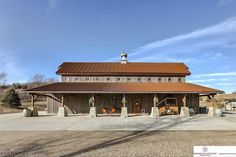 a large building with a brown roof and some trees