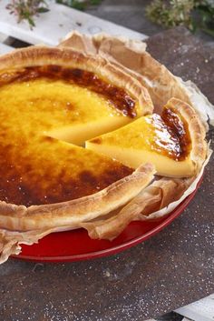 a pie sitting on top of a red plate with a piece of cheese in it