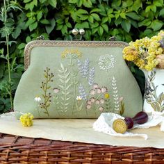 a purse sitting on top of a table next to flowers