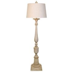 a white lamp with a beige shade on it's base and a light bulb in the middle