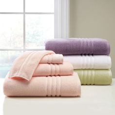 three towels stacked on top of each other in front of a window