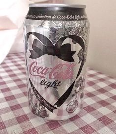 a can of coca cola sitting on top of a checkered tablecloth covered table